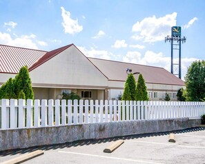 A hotel with a white picket fence, a red roof, and a sign indicating 'Quality Inn & Suites'. - Quality Inn & Suites Elizabethtown (Elizabethtown)