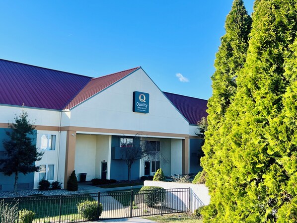 A hotel with a red roof, a sign reading "Quality Inn & Suites by Choice Hotels," and a well-maintained lawn with a fence. - Quality Inn & Suites Elizabethtown (Elizabethtown)