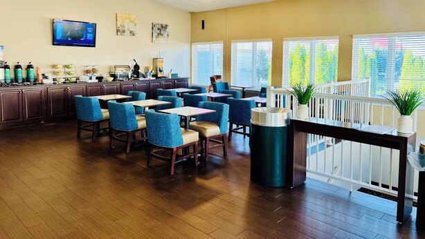 Un restaurante con suelo de madera, sillas azules y una barra con electrodomésticos de cocina.