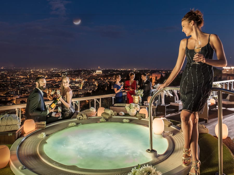 Terraço no terraço com hidromassagem, área de estar e vista para a cidade.