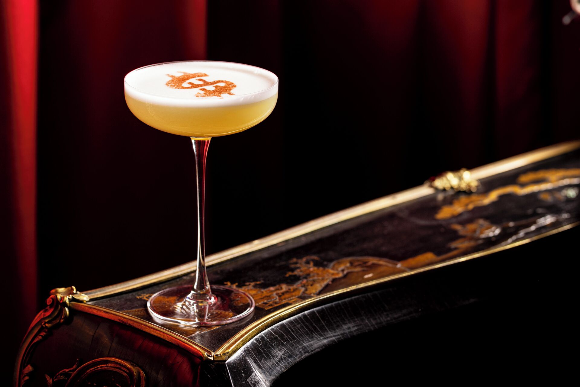 Un cocktail servi dans un verre, posé sur une surface en bois poli.