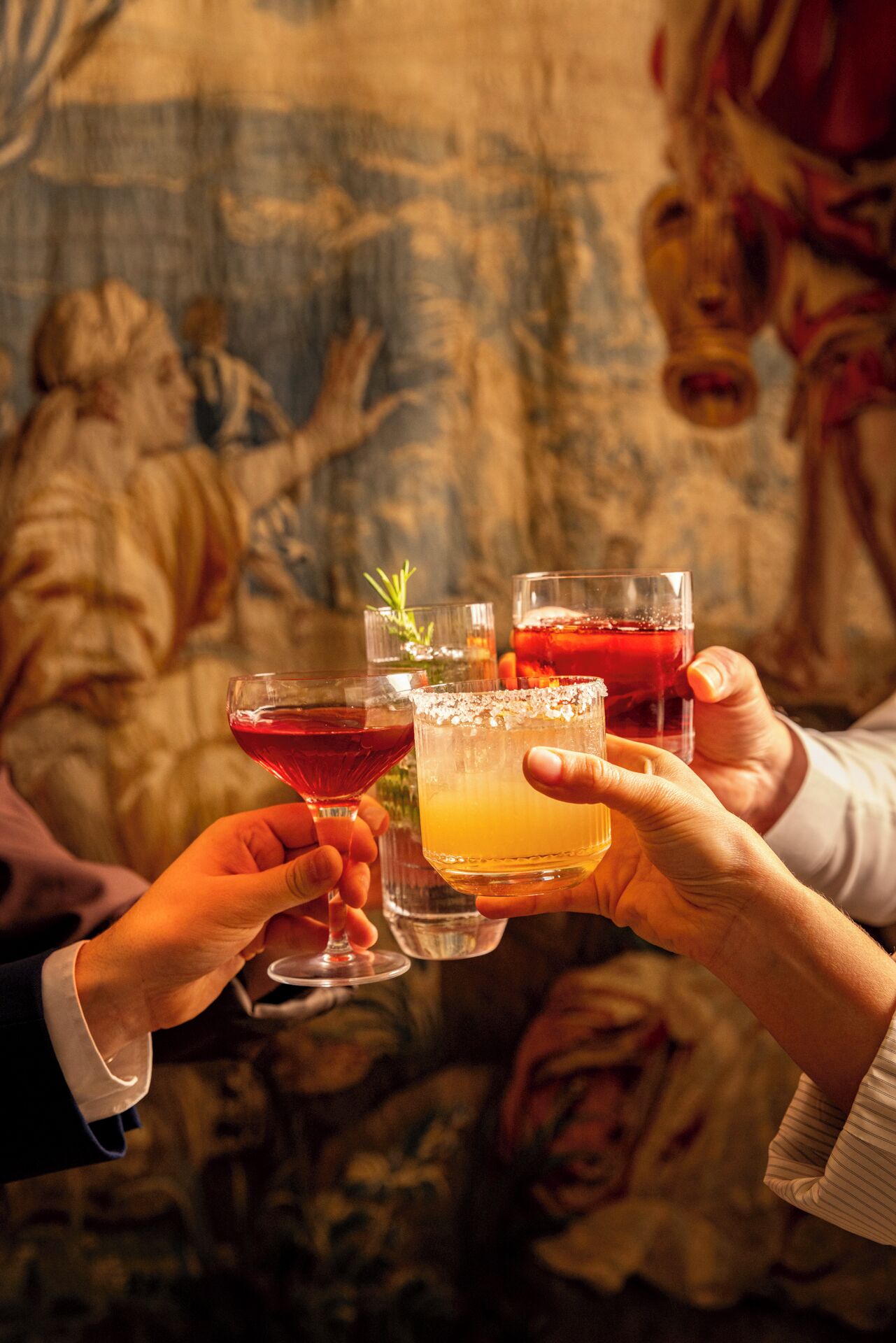 A group of people holding cocktail glasses.