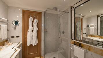 Un bagno moderno con doccia vetrata, porta in legno e un mobile lavabo in marmo.