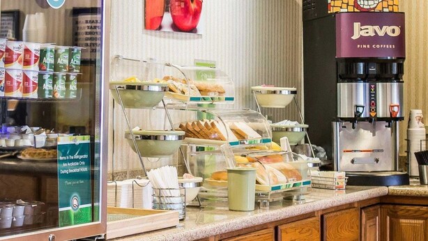 Een ontbijtbuffet met diverse etenswaren, een koelkast met drankjes en een koffiehoek.