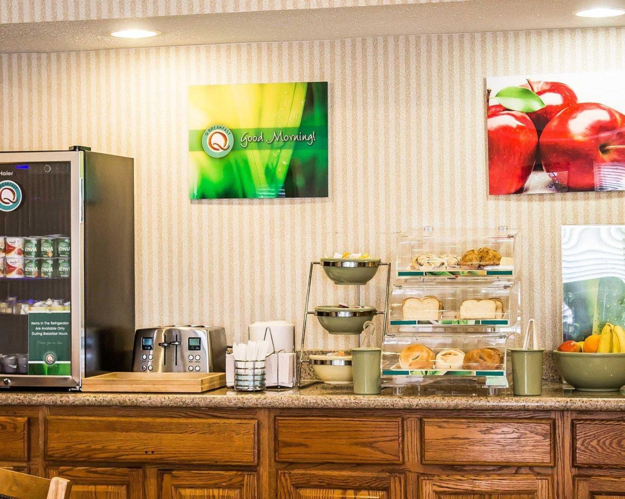 A breakfast bar with a coffee machine, a refrigerator, and a fruit bowl.