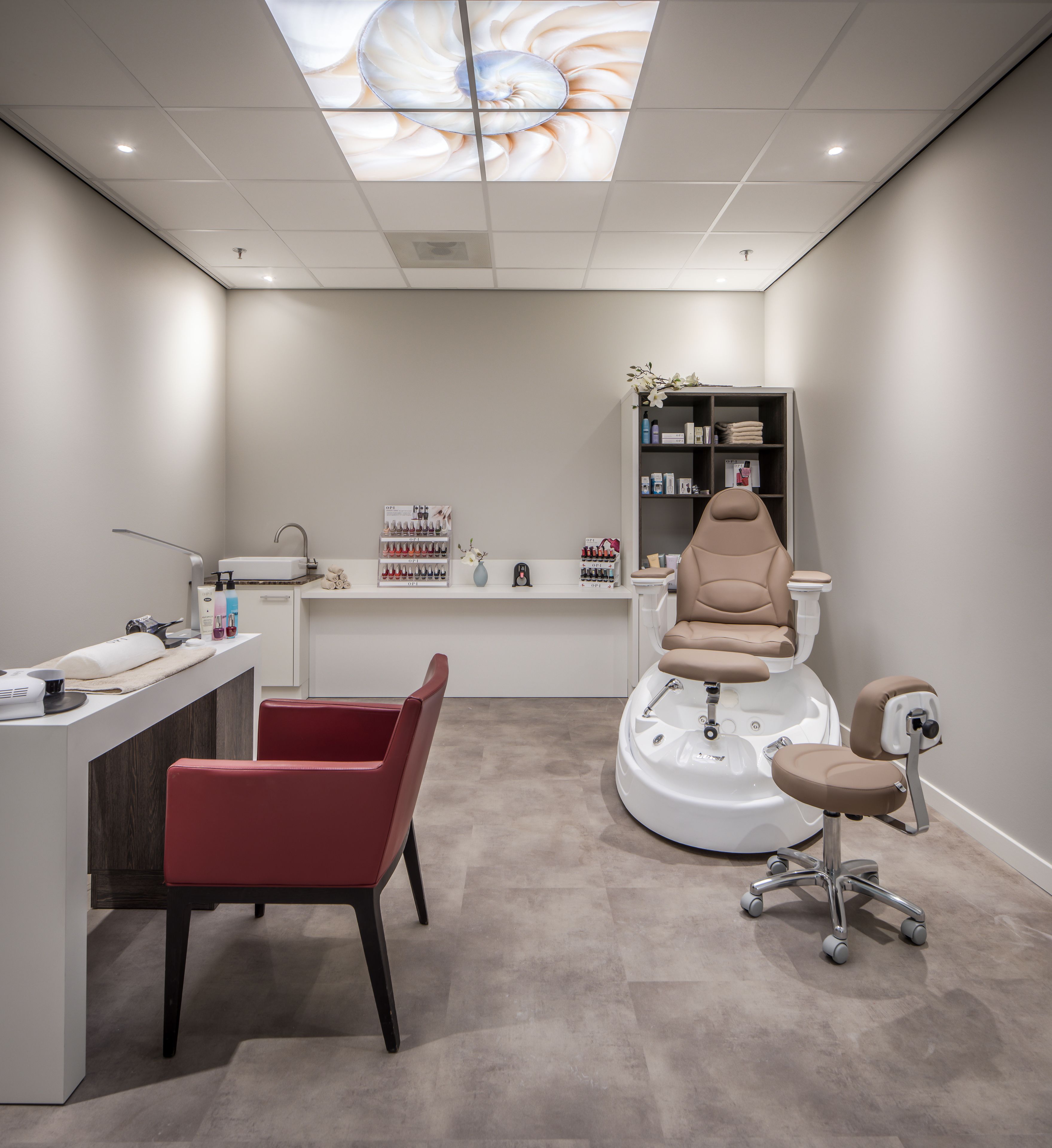 Un salón moderno con una estación central para lavar el cabello, un mostrador de recepción y un área de estar.