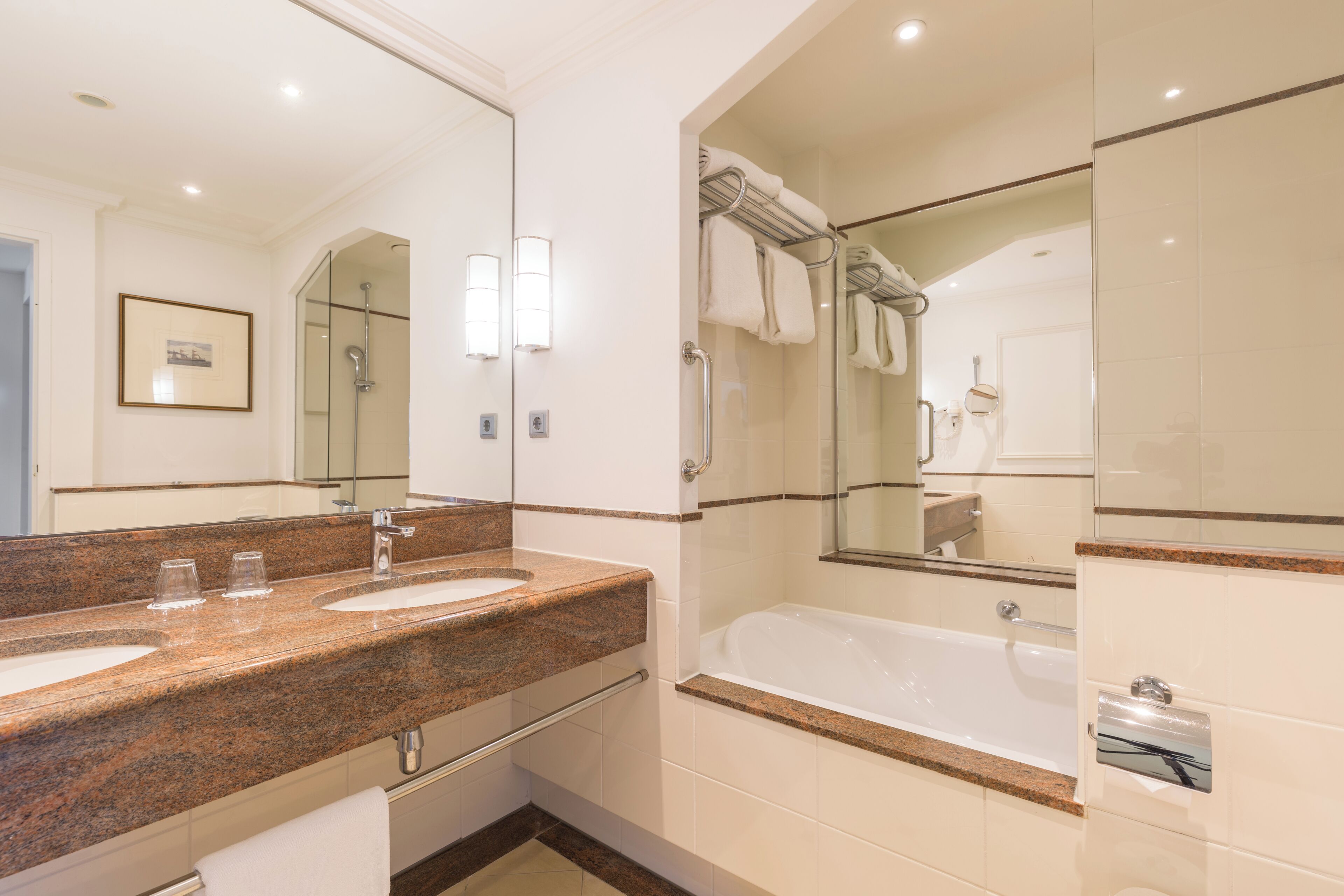 A modern bathroom with a double sink vanity, a glass-enclosed shower, and a standalone bathtub.