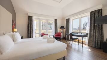 Een hotelkamer met een groot bed, een bureau, een stoel en een televisie.