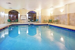 An indoor swimming pool with clear water, surrounded by green chairs and tables, and a sign indicating no lifeguard on duty. - Staybridge Suites Oak Ridge by IHG (Oak Ridge)