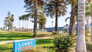 A lobby area with a sign reading "LOBBY," surrounded by trees and a grassy area.