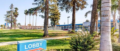 A lobby area with a sign reading "LOBBY," surrounded by trees and a grassy area.