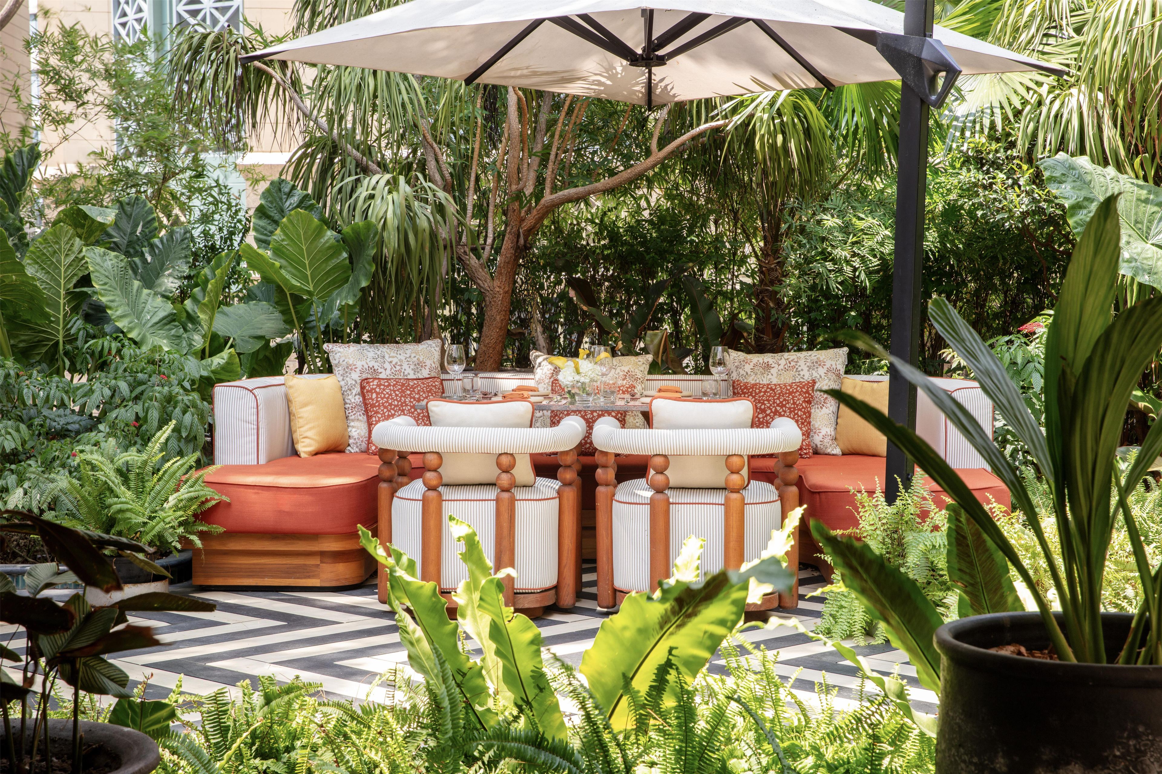 An outdoor seating area with a table, chairs, and a large umbrella.