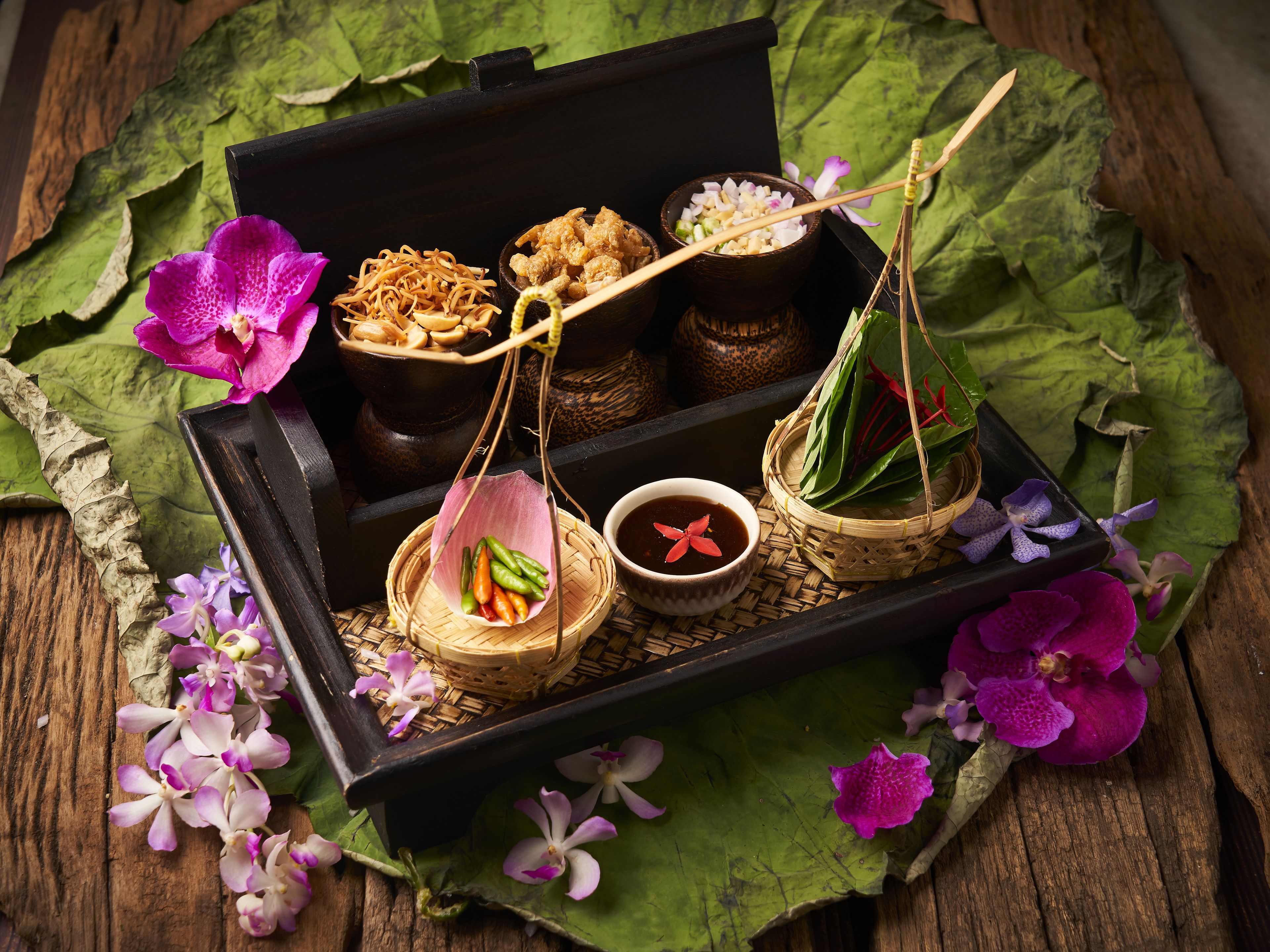 A traditional wooden box with food items and flowers.