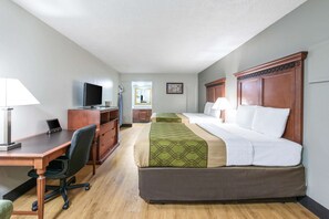 Relax in a spacious room with a large bed, desk, and mounted TV.