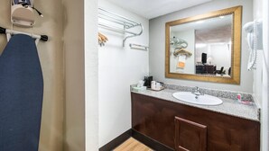 A bathroom with a sink, mirror, towel rack, and a hairdryer. - Rodeway Inn St. Joseph (Saint Joseph)