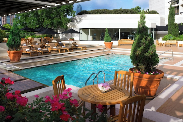 Een buitenzwembad, parasols voor strand/zwembad