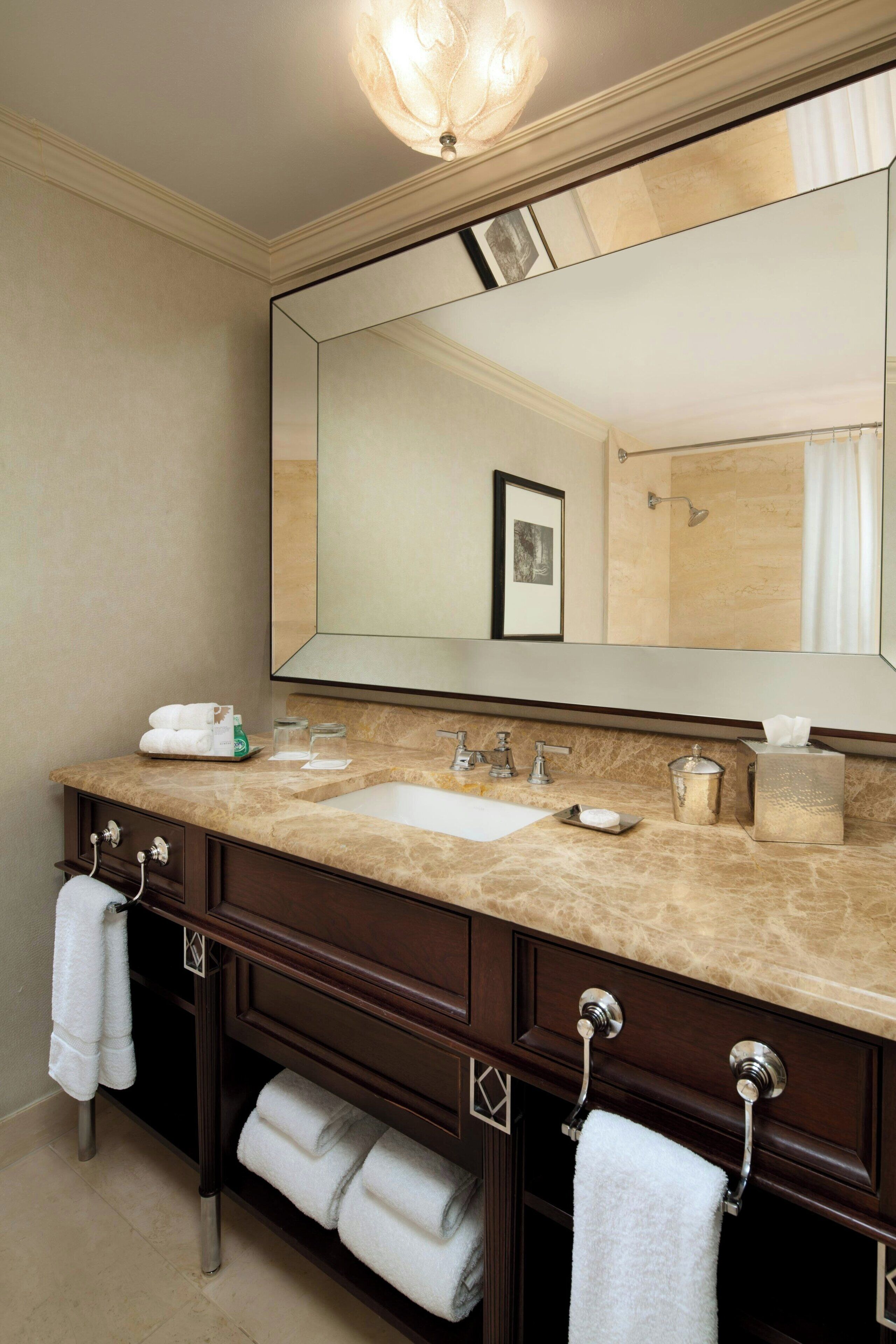 A bathroom with a double sink vanity, a large mirror, and a towel rack.