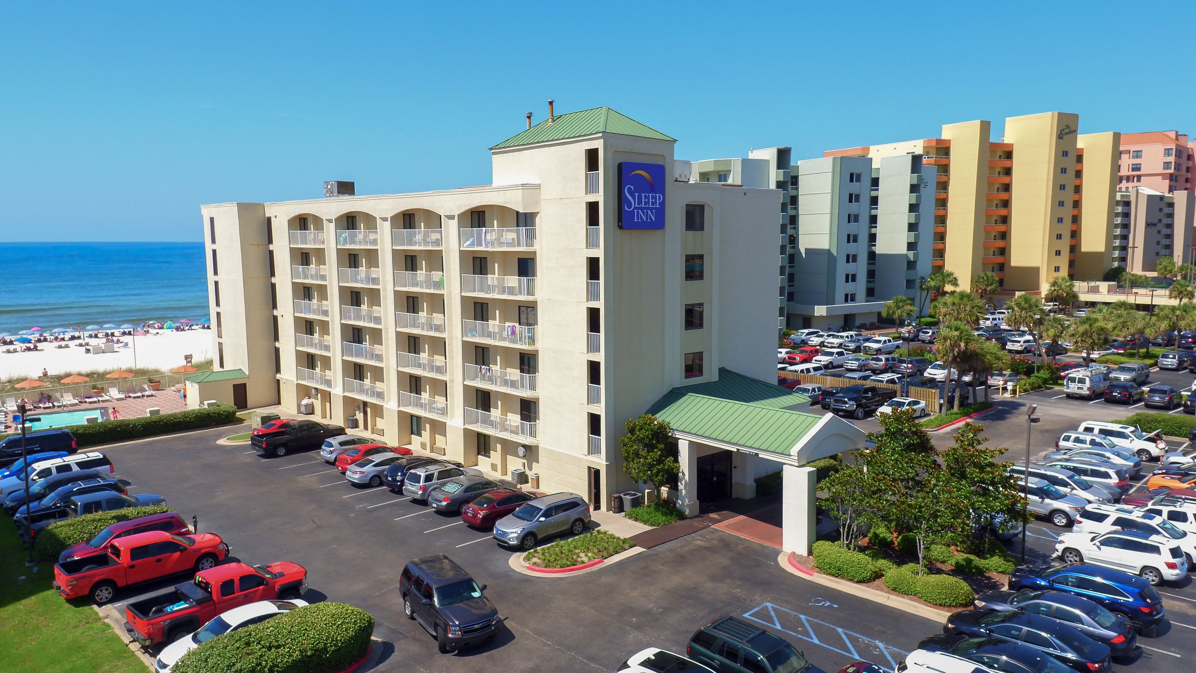 Un hôtel à plusieurs étages doté d’une piscine et d’un parking.