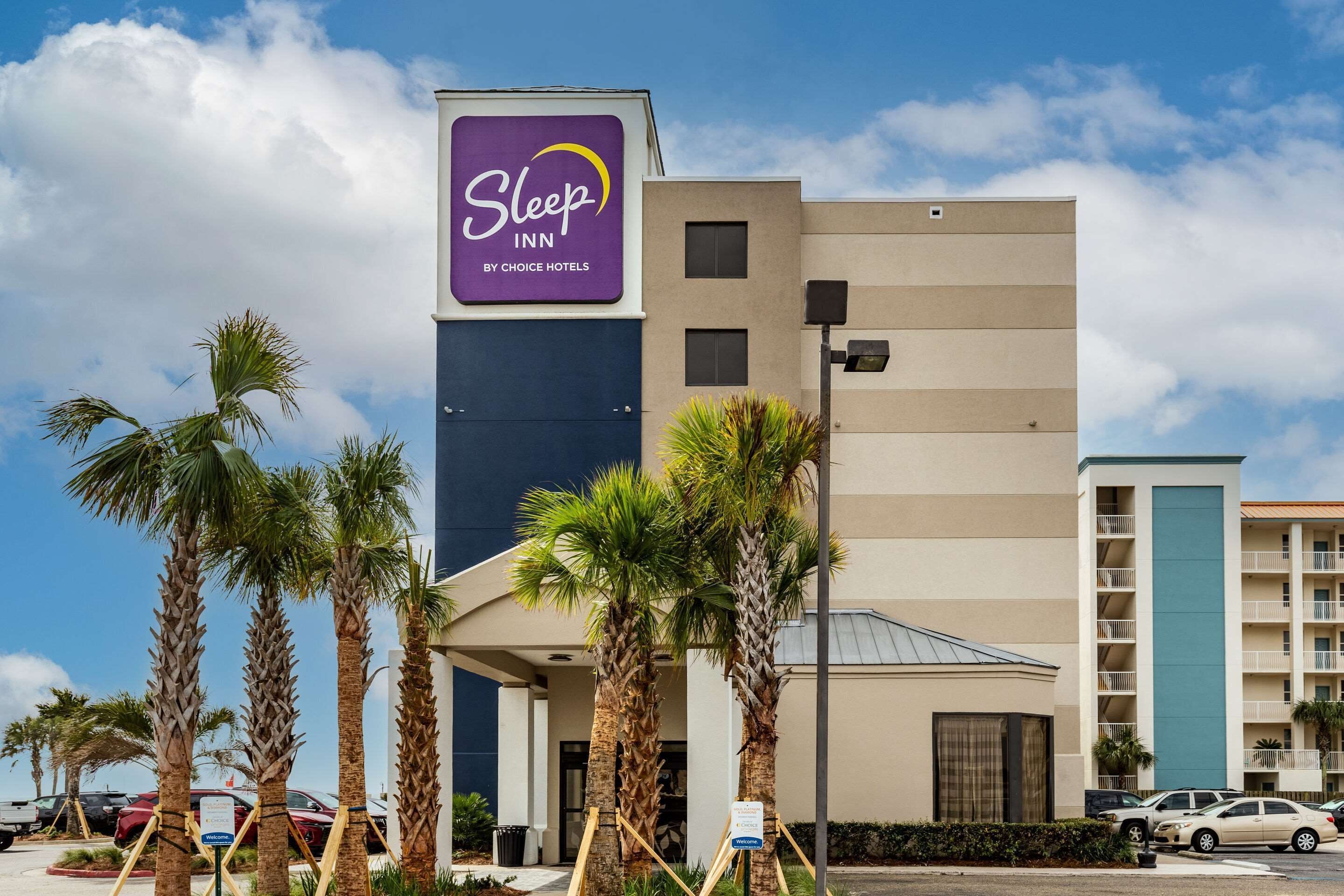 Edificio di un Sleep Inn by Choice Hotels dal design moderno, con palme davanti e cielo sereno.