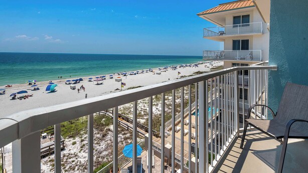 A balcony with a view of a beach and ocean.