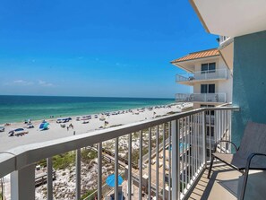 A balcony with a view of a beach and ocean.