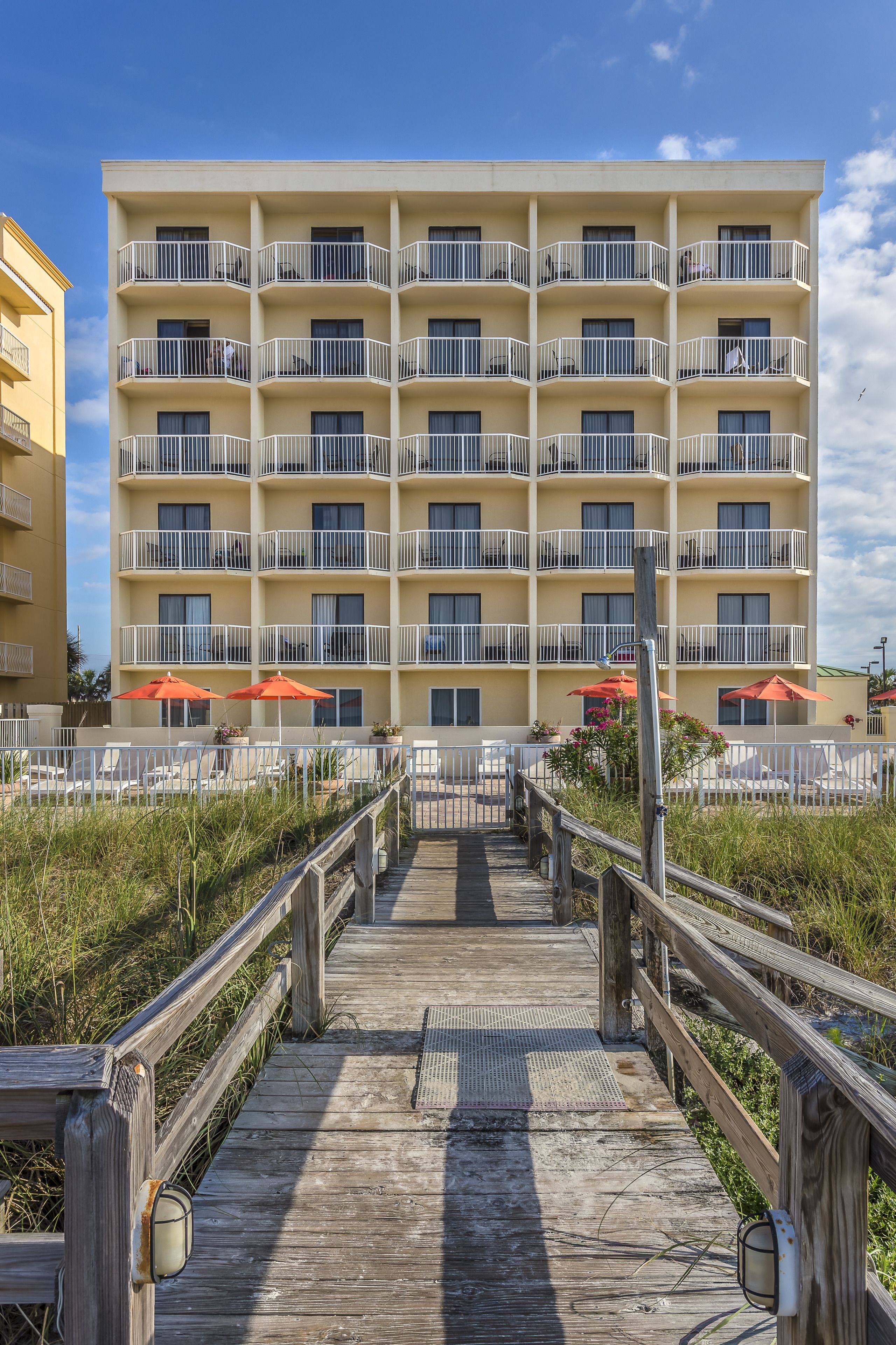 A multi-story hotel with balconies and outdoor seating areas.