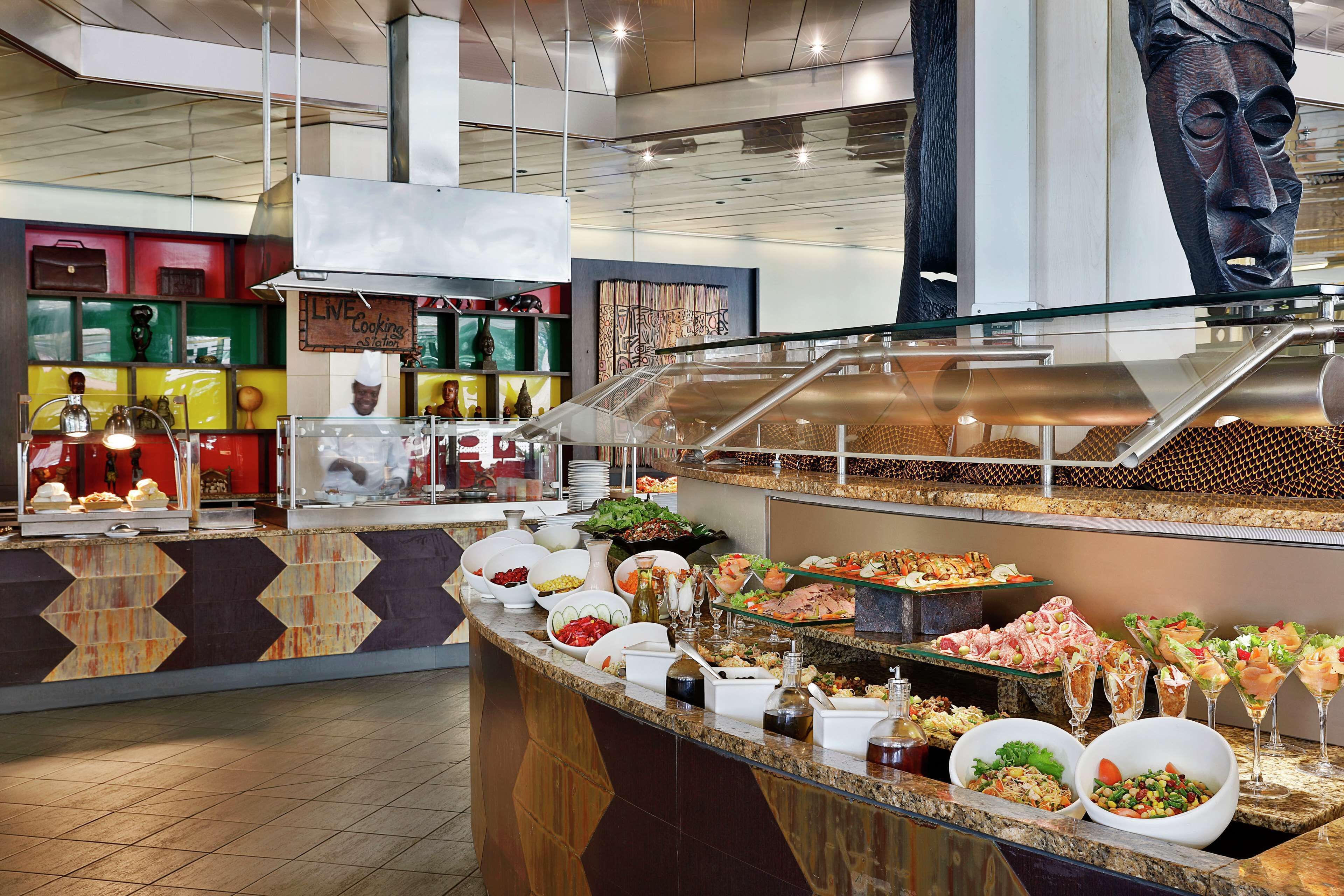 A buffet area with various food options and a live cooking station.