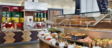 A buffet area with various food options and a live cooking station.
