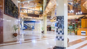 A spacious lobby with a marble floor, a staircase, and a reception area. - Transcorp Hilton Abuja (Abuja)