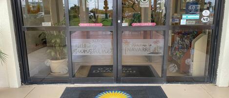 A hotel entrance with automatic sliding doors, a welcome mat, and a sign for Days Inn & Suites by Wyndham.