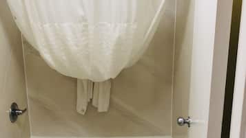 Une salle de bain avec une baignoire, un rideau de douche et une serviette accrochée au mur.