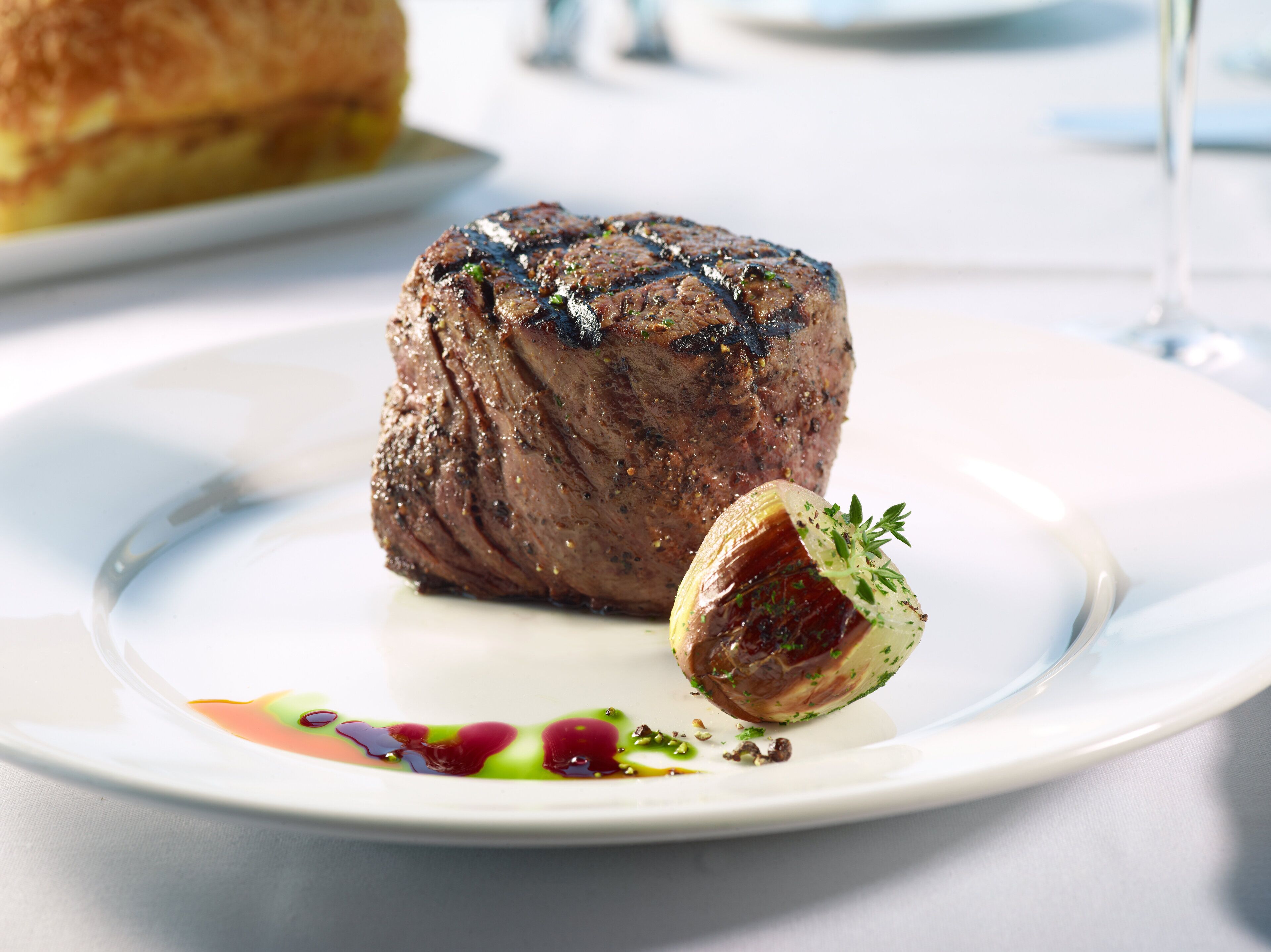 A steak with a garnish on a plate.