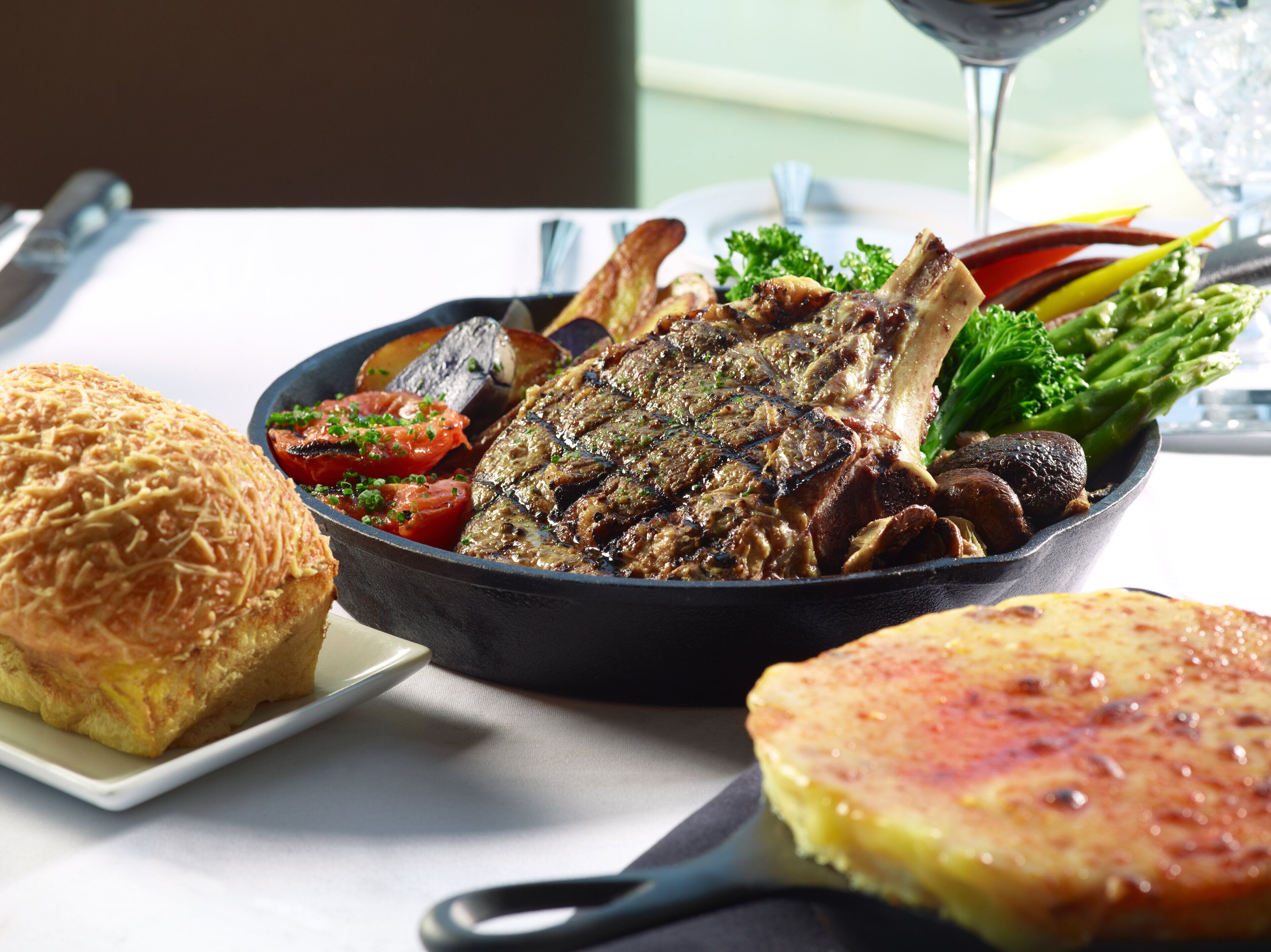 Un repas composé de viande grillée, de légumes et de pain, servi sur une table.