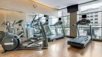 A gym with treadmills, elliptical machines, and a stationary bike.
