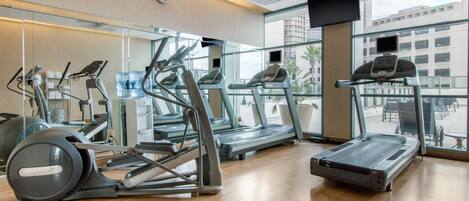 A gym with treadmills, elliptical machines, and a stationary bike.