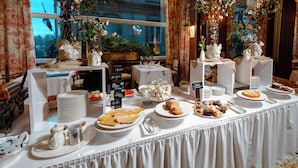 Een buffet met verschillende gerechten, borden en een bord met begroetingen in meerdere talen.