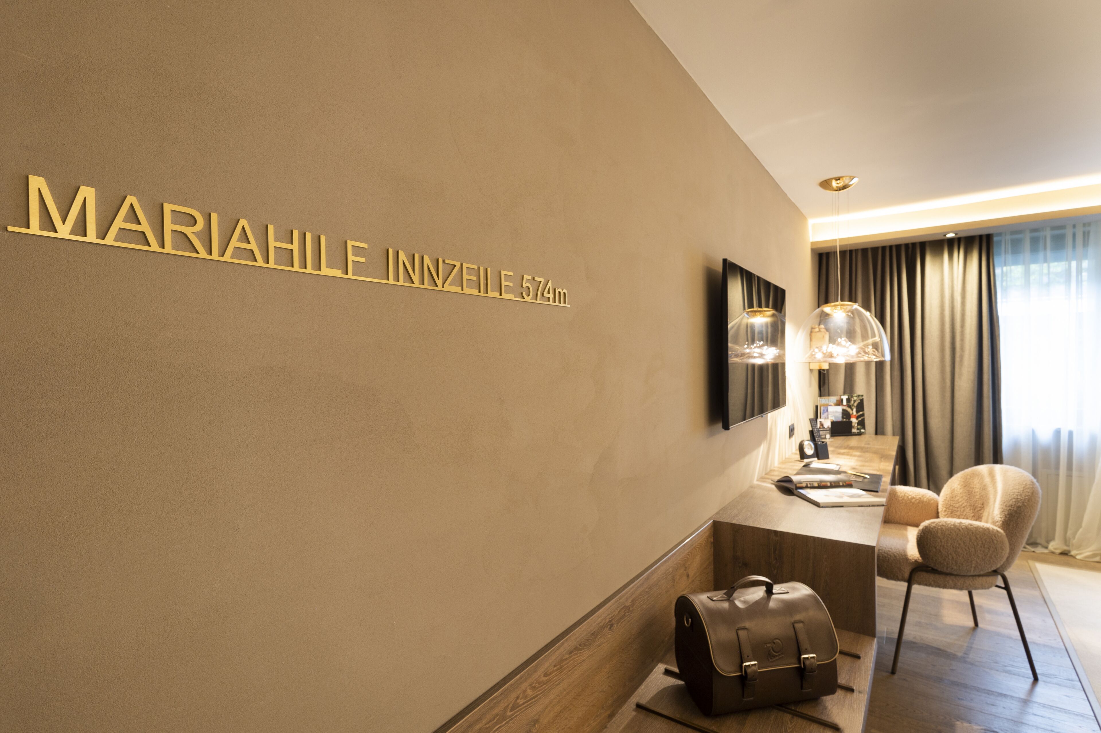 Une chambre d’hôtel moderne au design minimaliste, dotée d’un grand lit, d’un bureau avec une lampe et offrant une vue sur la ville par la fenêtre.