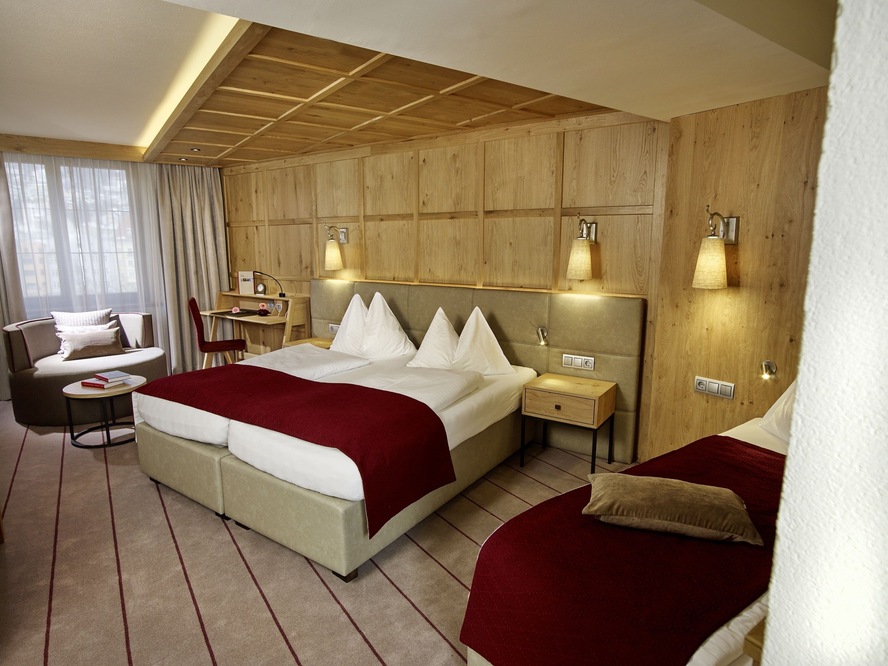 Una habitación de hotel con una cama grande, un escritorio, una silla y un sofá.