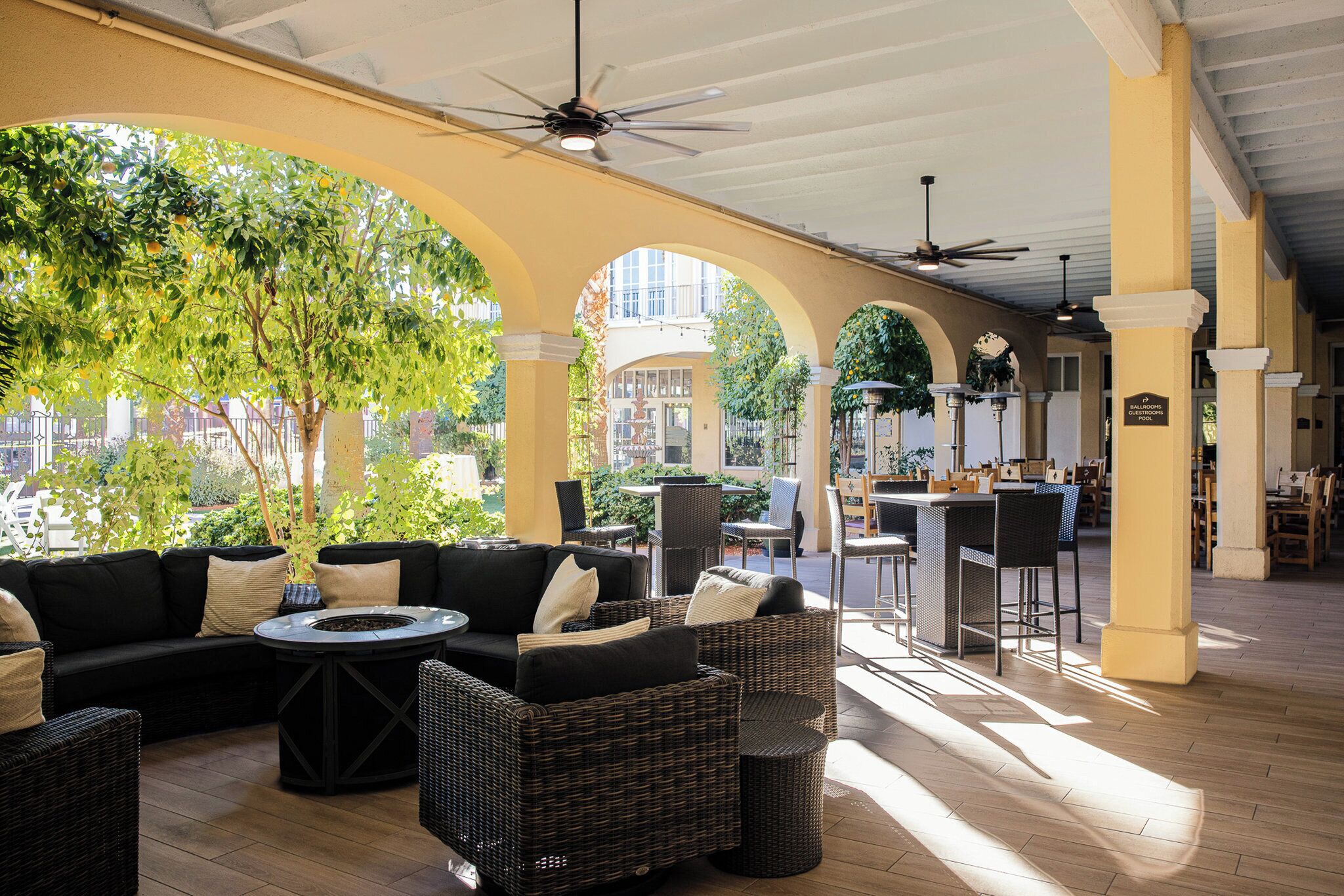 An outdoor seating area with wicker furniture, a fire pit, and a view of the street.