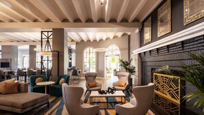 A spacious lounge area with modern furniture, a fireplace, and large windows. - Crowne Plaza Phoenix - Chandler Golf Resort by IHG (Chandler)
