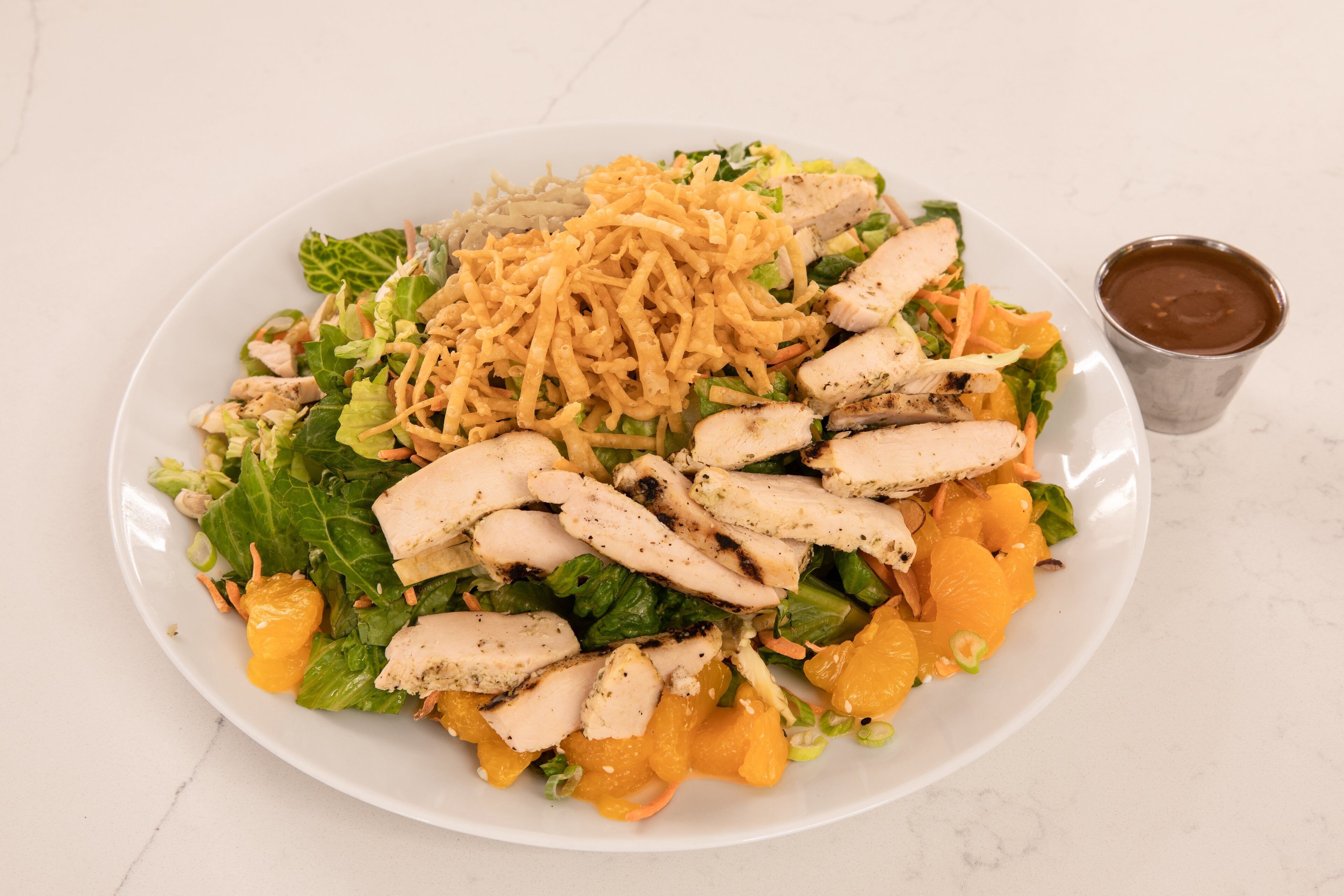 A plate of food with chicken, shredded cheese, and vegetables.