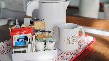 Una bandeja de desayuno con una taza, una cafetera y una caja de queso Tette y cartones de leche.