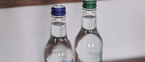 Two bottles of Strathmof water and two empty glass tumblers on a wooden table.