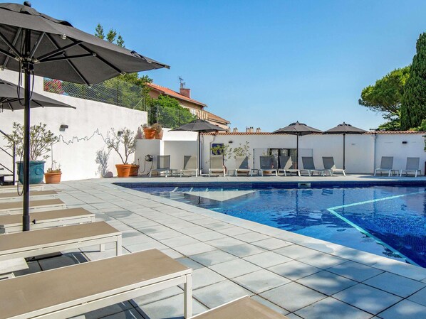 Een seizoensgebonden buitenzwembad, parasols voor strand/zwembad