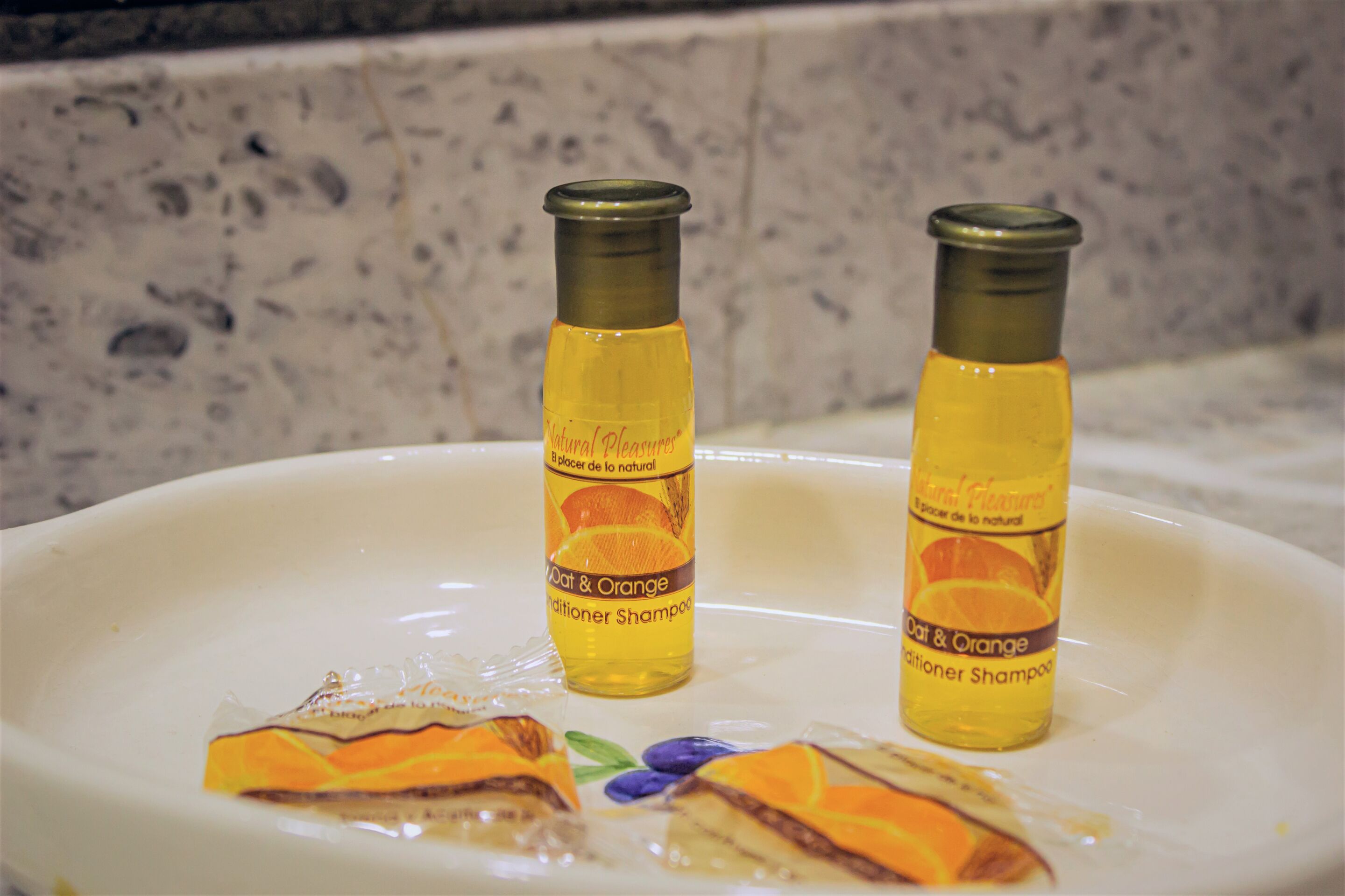 Two bottles of conditioner shampoo on a white plate.