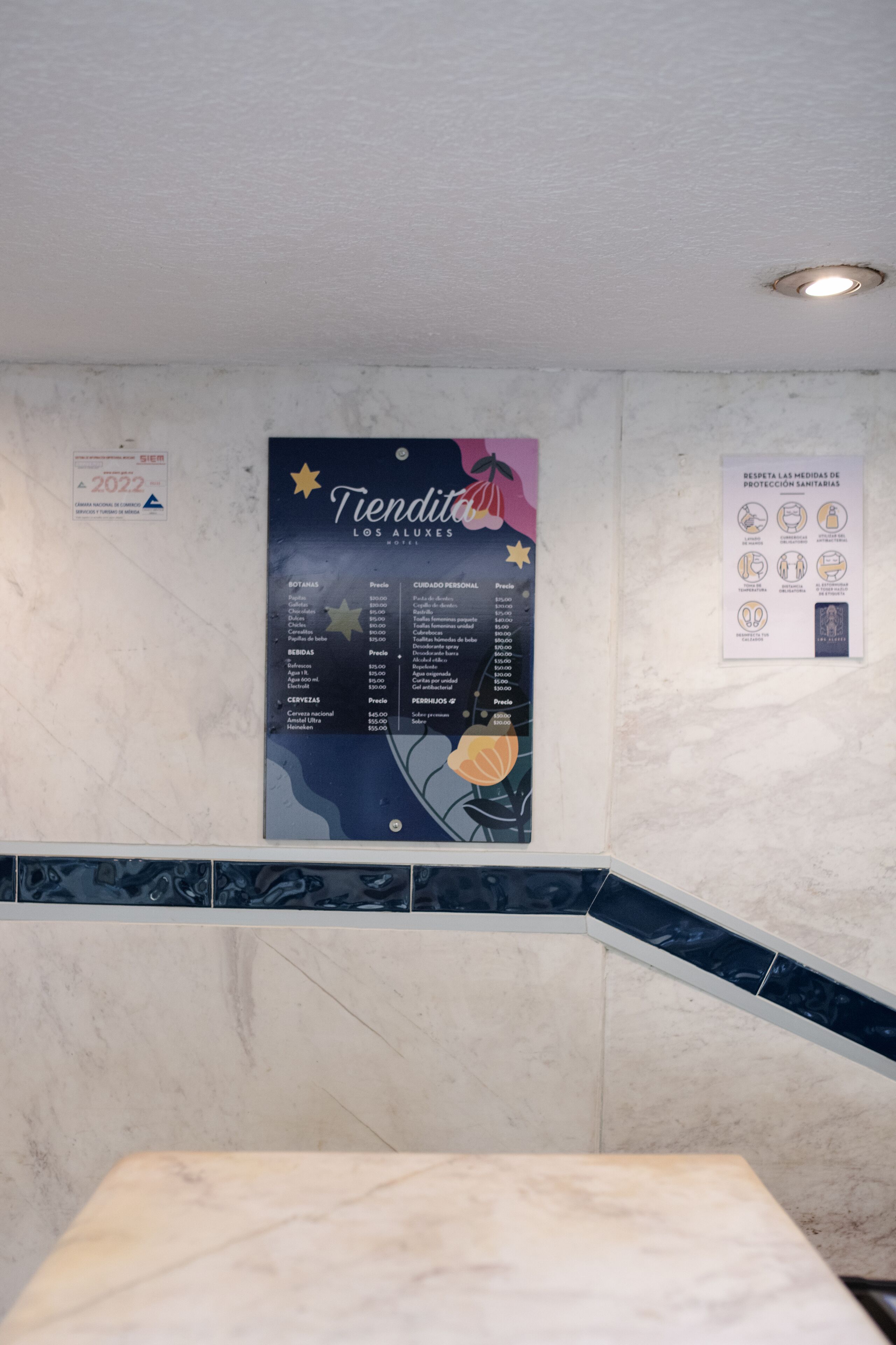 Une salle de bain avec une affiche au mur indiquant les prix des différents services proposés.