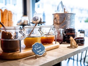 Un présentoir de produits alimentaires avec des pots de sauces et une pancarte indiquant les pâtes locales.