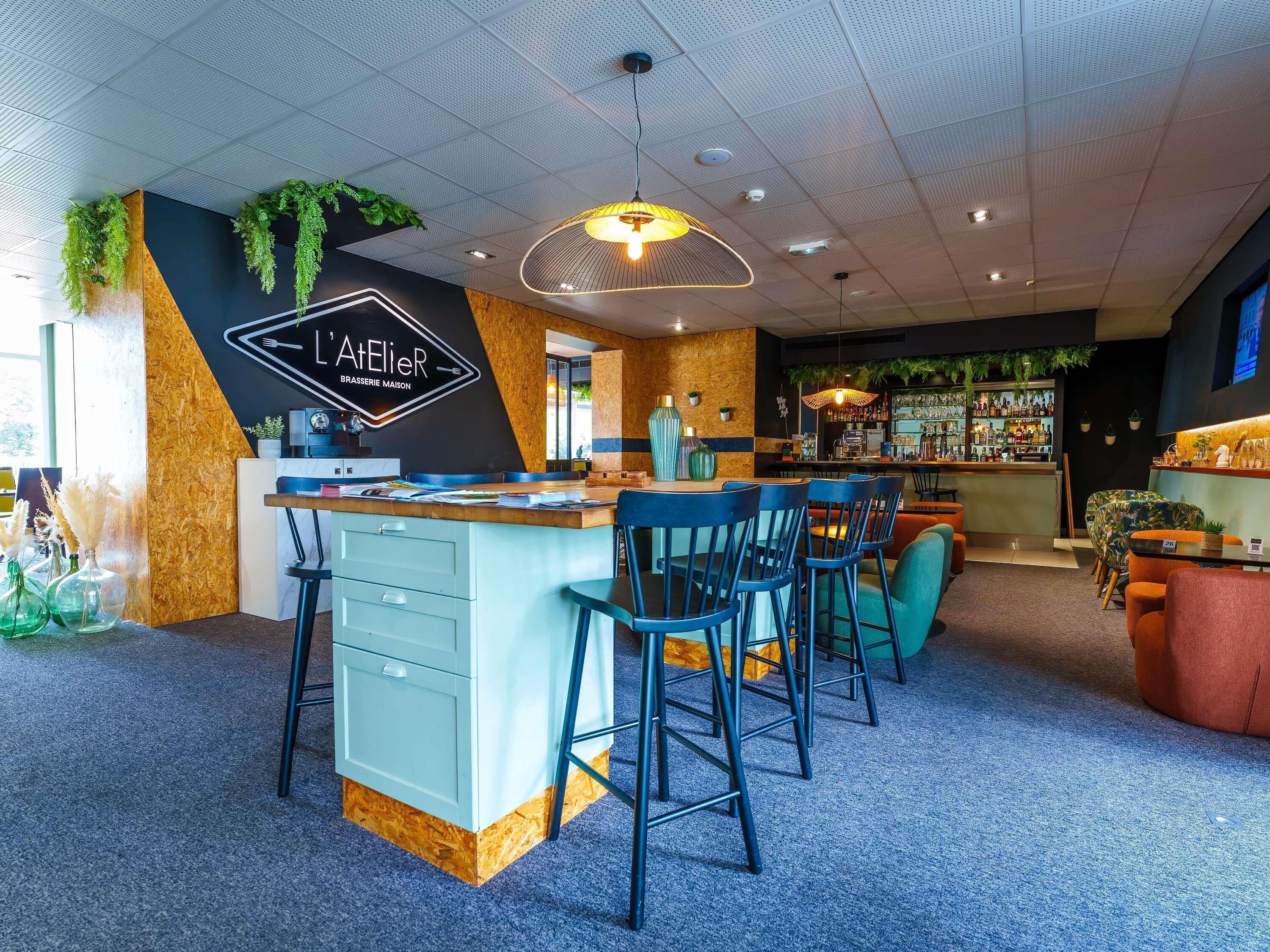 Een moderne bar met een toog, barstoelen en een zithoek met stoelen en tafels.