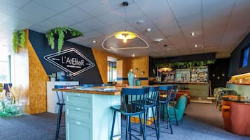 Een moderne bar met een toog, barstoelen en een zithoek met stoelen en tafels.