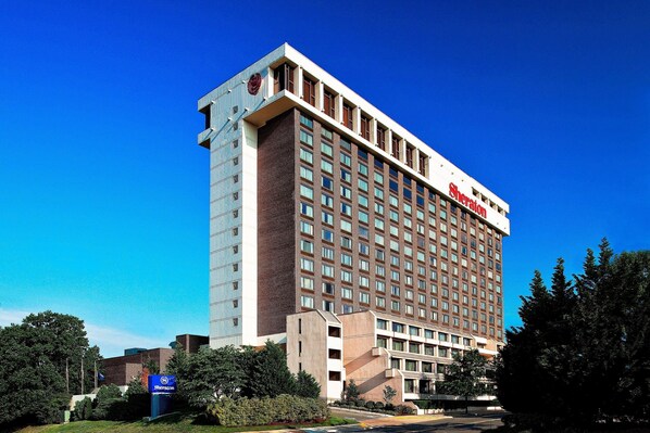 A Sheraton hotel with a modern design, featuring a prominent red logo on the top. - Sheraton Pentagon City Hotel (Arlington)